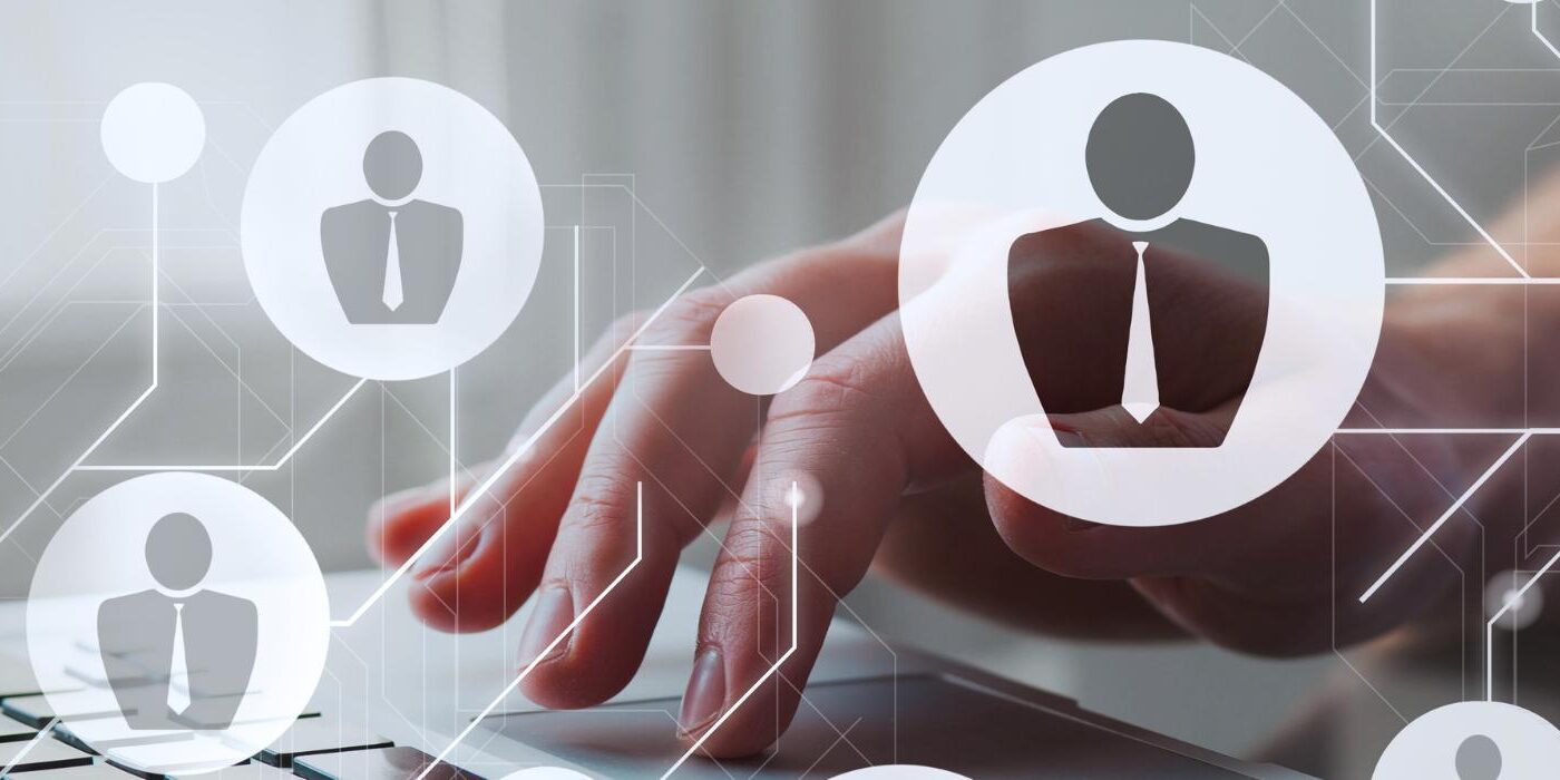 MID GmbH | KI-gestütztes Recruiting Tool, Hand tippt auf Laptop-Tastatur mit eingeblendeten Icons als Symbol für digitales Recruiting und KI-Matching.